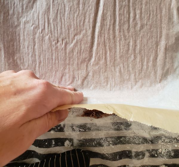 Peeling parchment paper off a cake.
