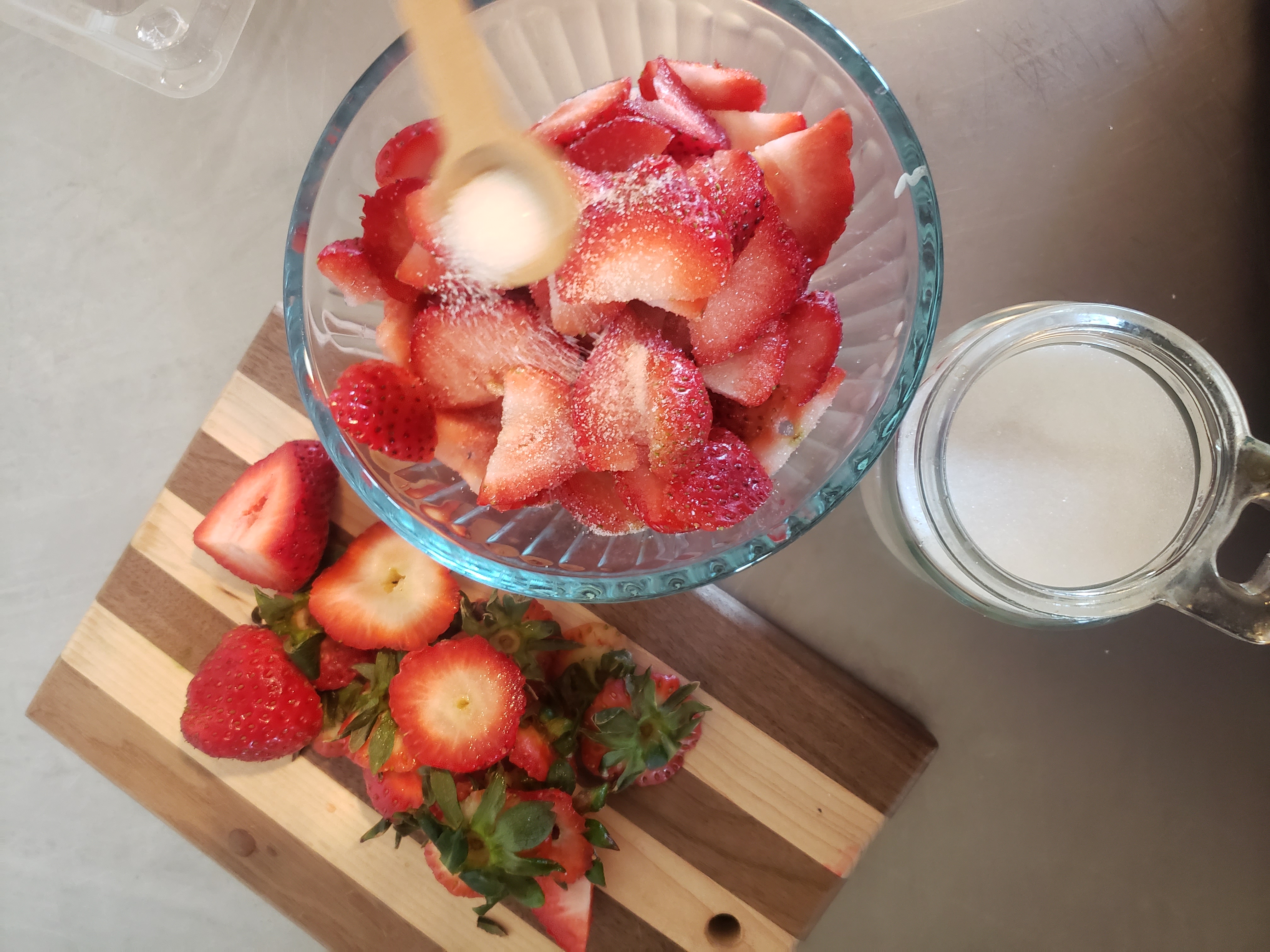 Sugar being added to sliced strawberries