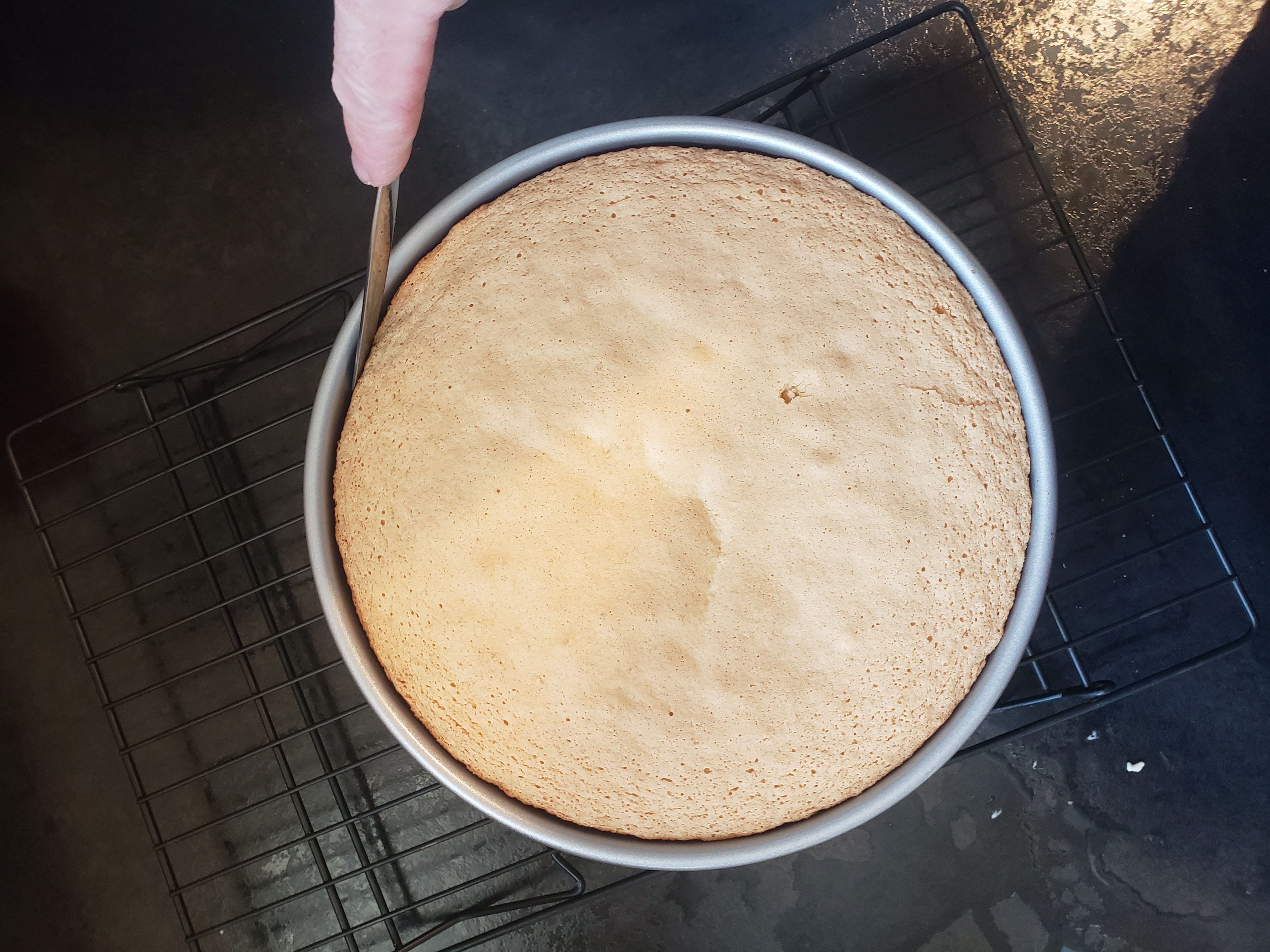 scoring the edges of a cake in a pan