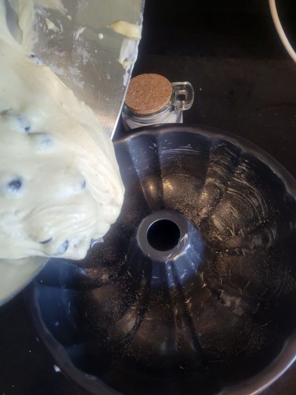 Adding cake batter to a greased bundt pan