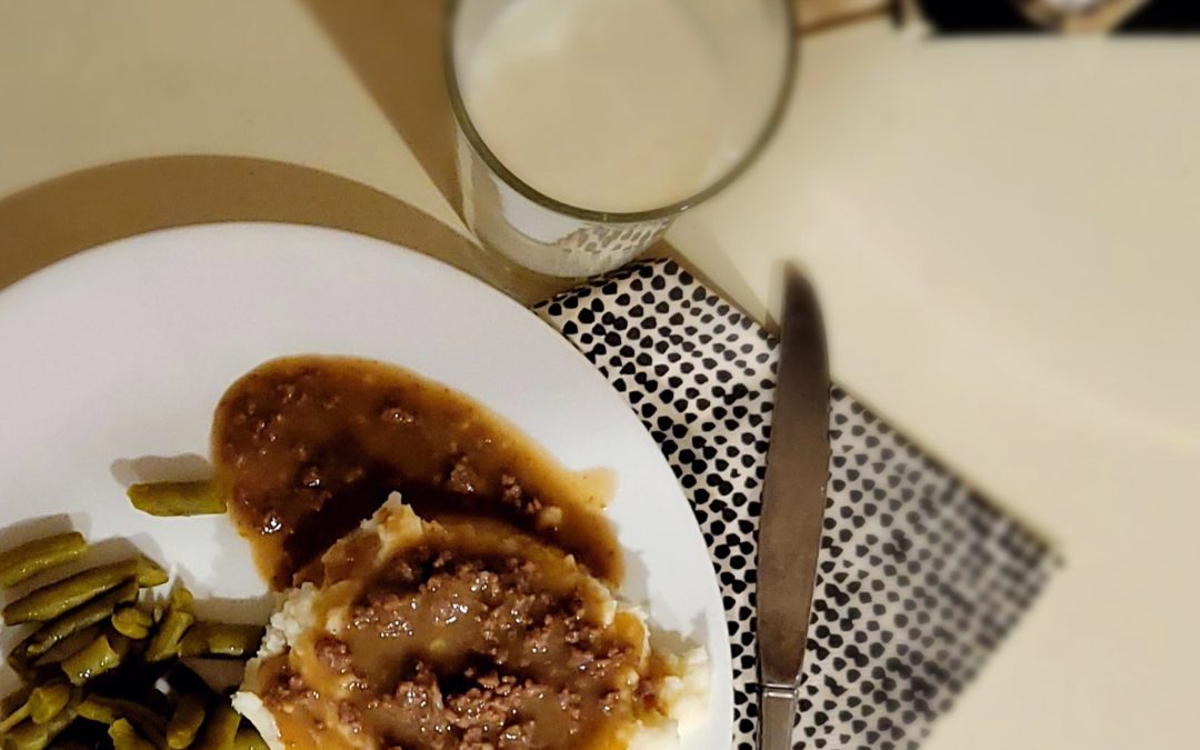 Meat gravy and mashed potatoes on a white plate