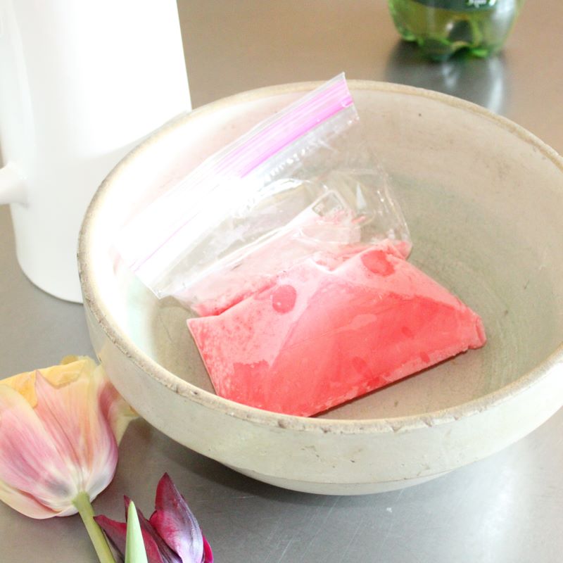 Frozen rhubarb syrup thawing in a bowl